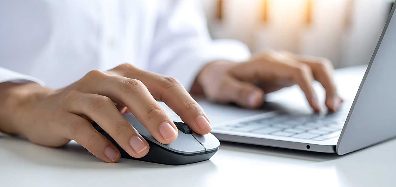 Bedienung von Laptop und Maus durch eine Person